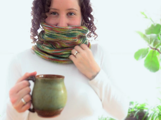 image of woman wearing knit cowl around her neck holding a coffee mug