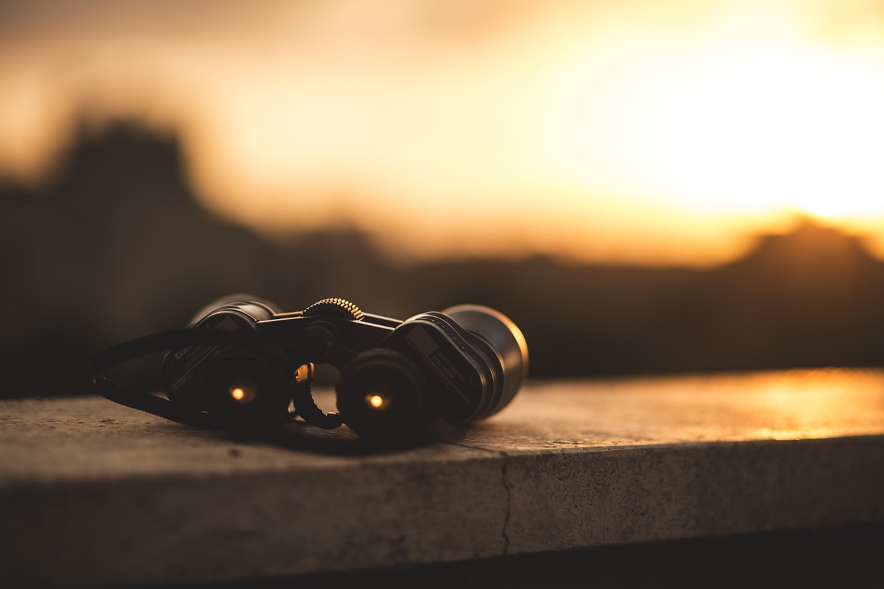 binoculars in sunset on railing