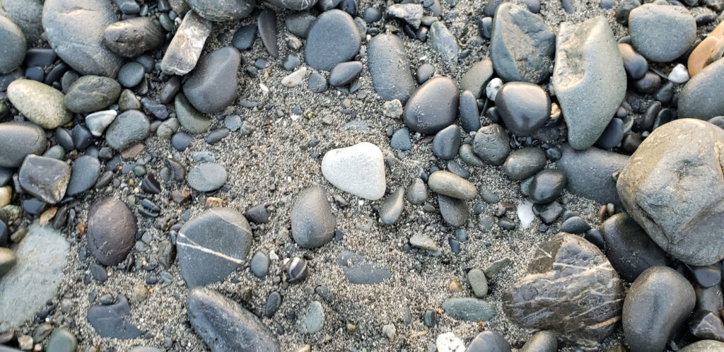 Image of a rock shaped like a heart in the sand.