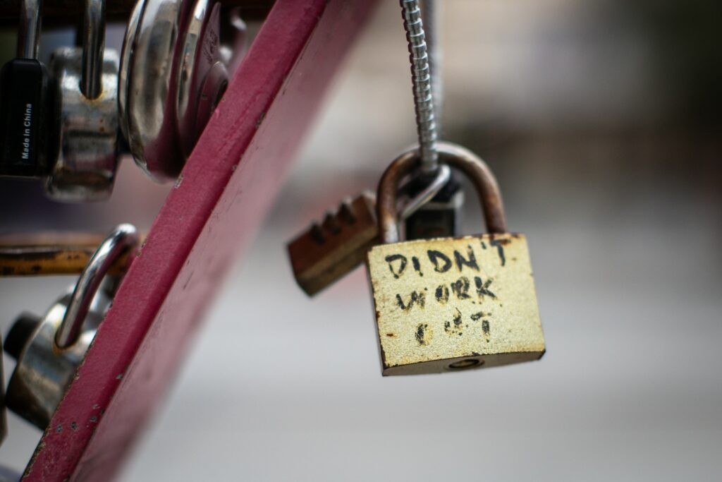 padlock secured to metal with the words "didn't work out" on it. A sign of divorce